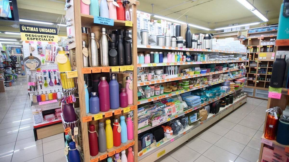 Una estantería repleta de cantimploras, tuppers o termos