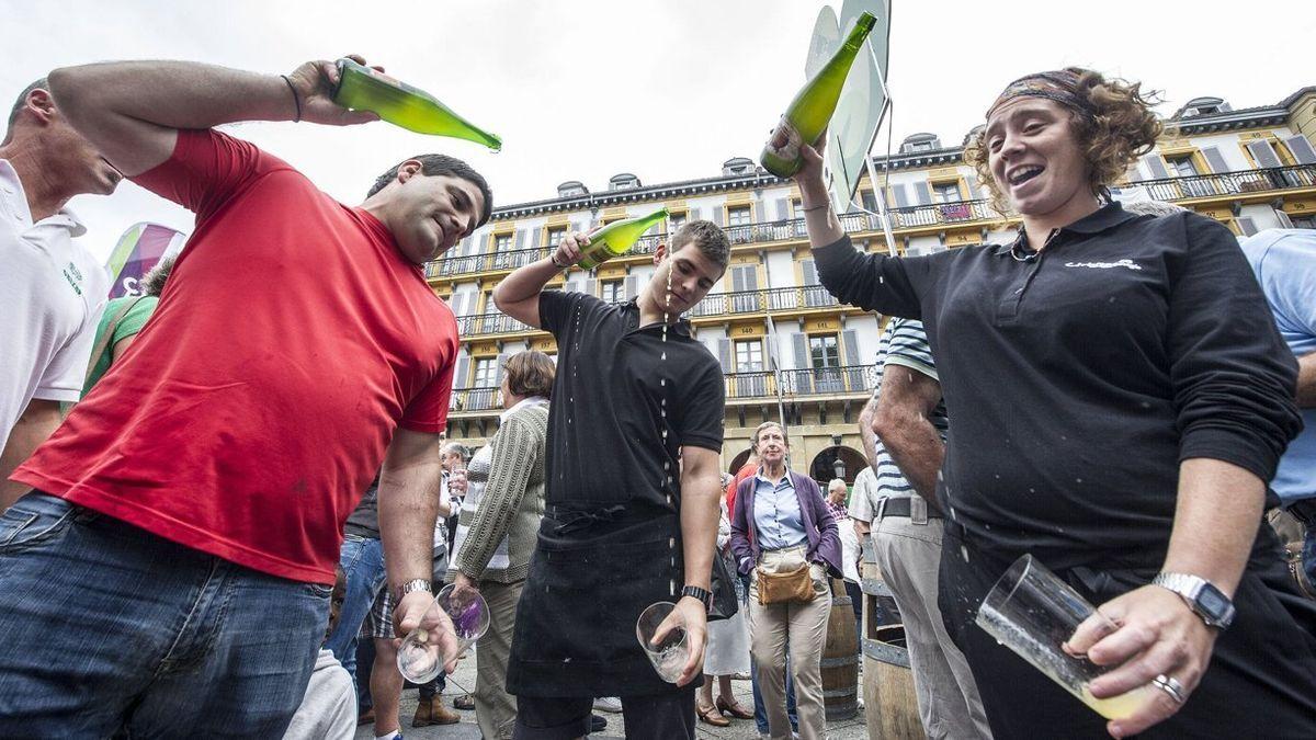 Un grupo de personas escancia sidra en la plaza de la Constitución de Donostia