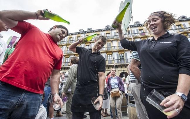Un grupo de personas escancia sidra en la plaza de la Constitución de Donostia Un grupo de personas escancia sidra en la plaza de la Constitución de Donostia