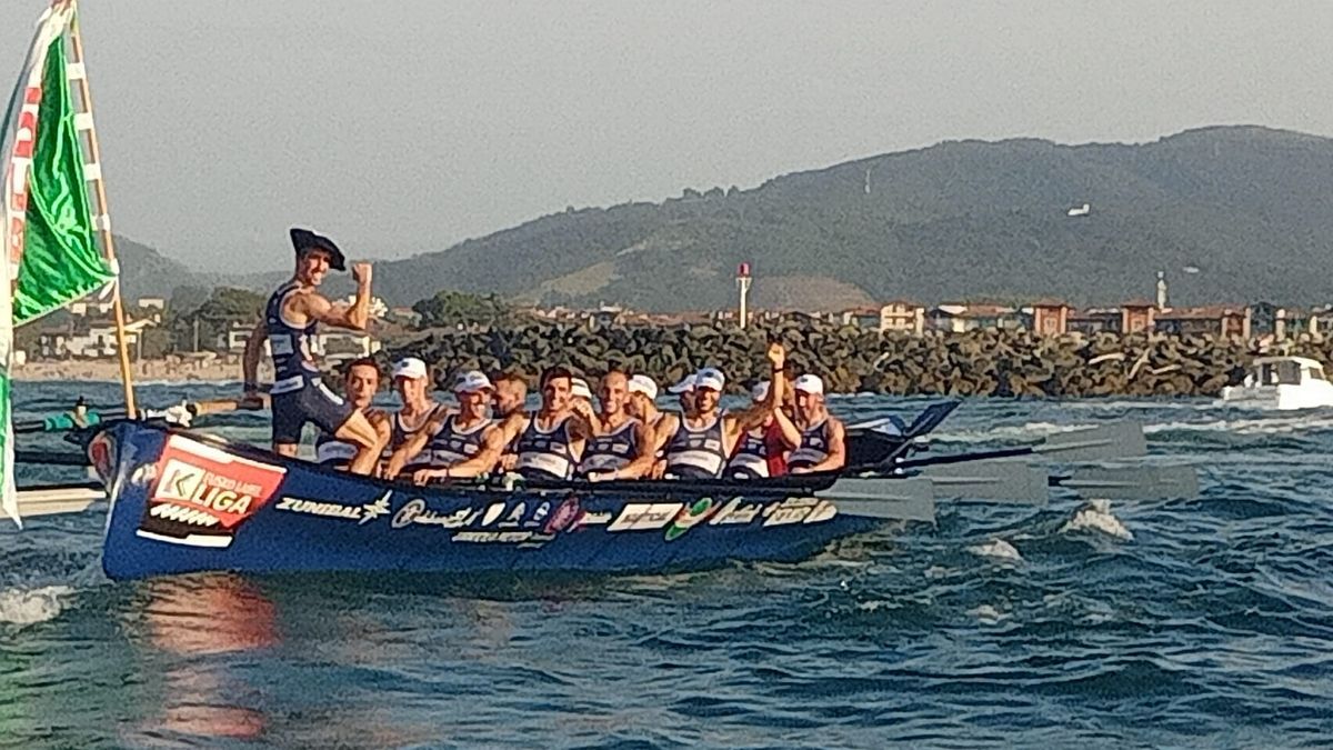 El patrón de Urdaibai, Gorka Aranberri, hace un gesto de victoria con la bandera de Hondarribia en la popa.