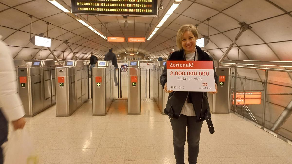 Nieves con el cartel que le acredita como la viajera 2.000 millones en la historia del metro de Bilbao