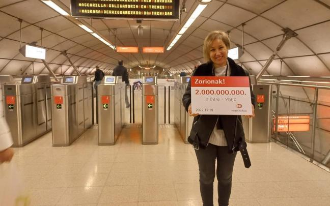 Nieves con el cartel que le acredita como la viajera 2.000 millones en la historia del metro de Bilbao