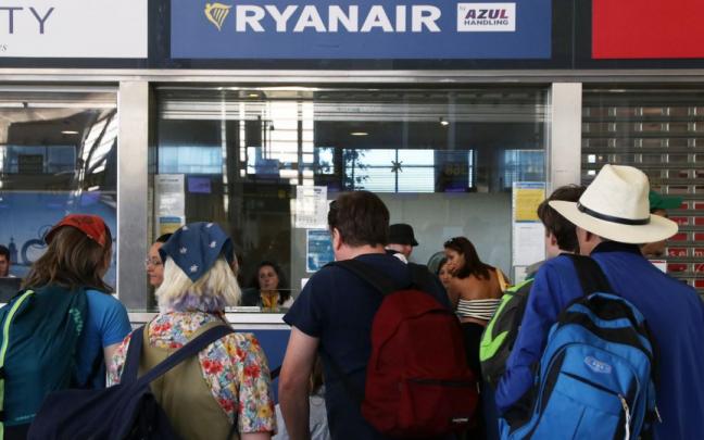 Usuarios de Ryanair esperan a recibir información en la ventanilla de la compañía Usuarios de Ryanair esperan a recibir información en la ventanilla de la compañía