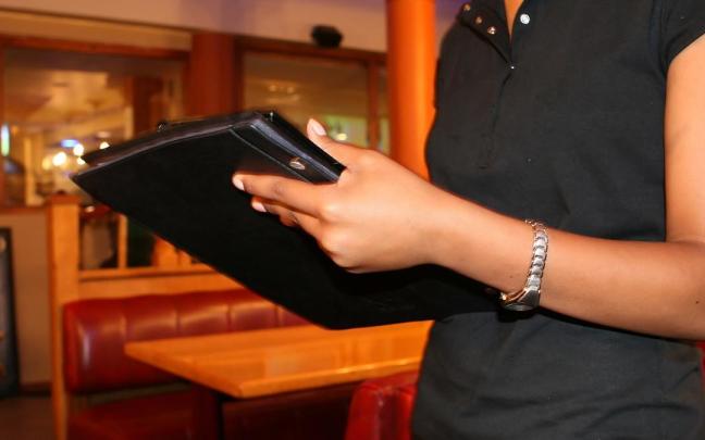 Una camarera toma nota en un bar