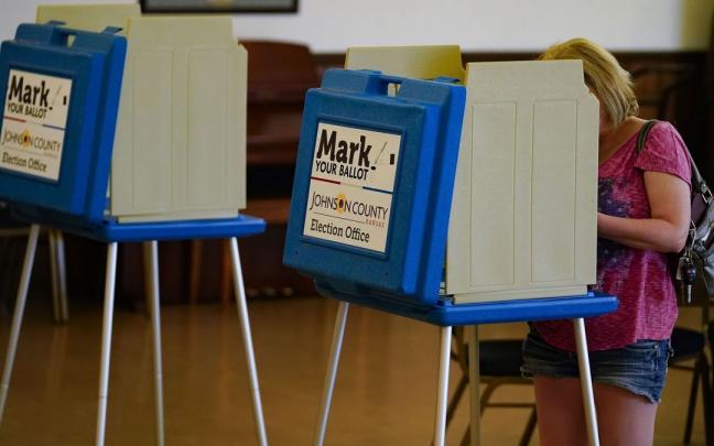 Una mujer en un centro de votación en Kansas Una mujer en un centro de votación en Kansas