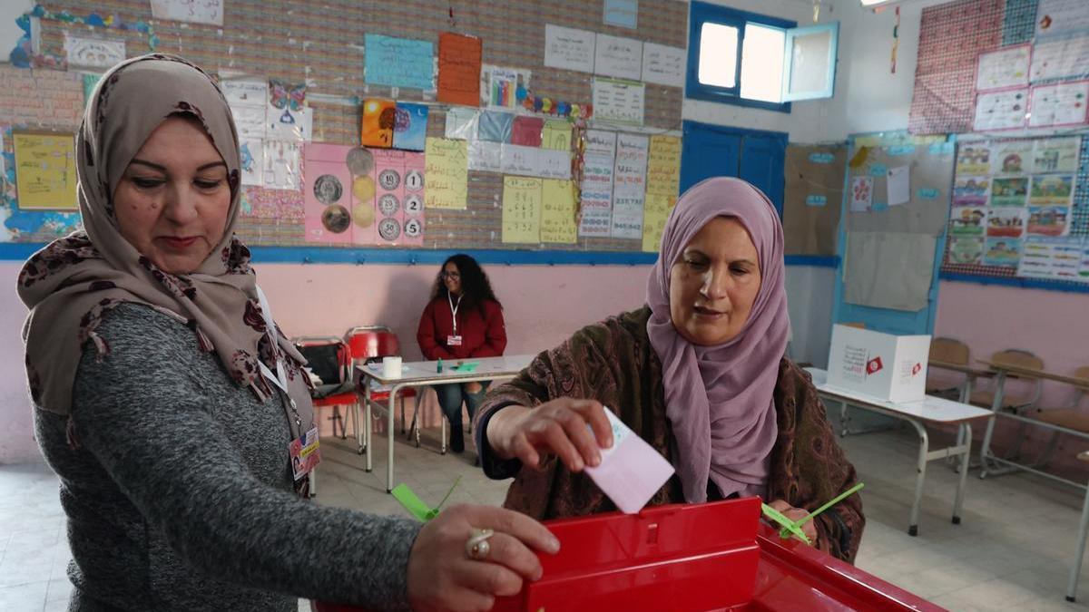 Una mujer deposita su voto en un colegio electoral de Túnez.