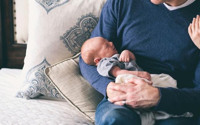 Un padre con su bebé en brazos Un padre con su bebé en brazos