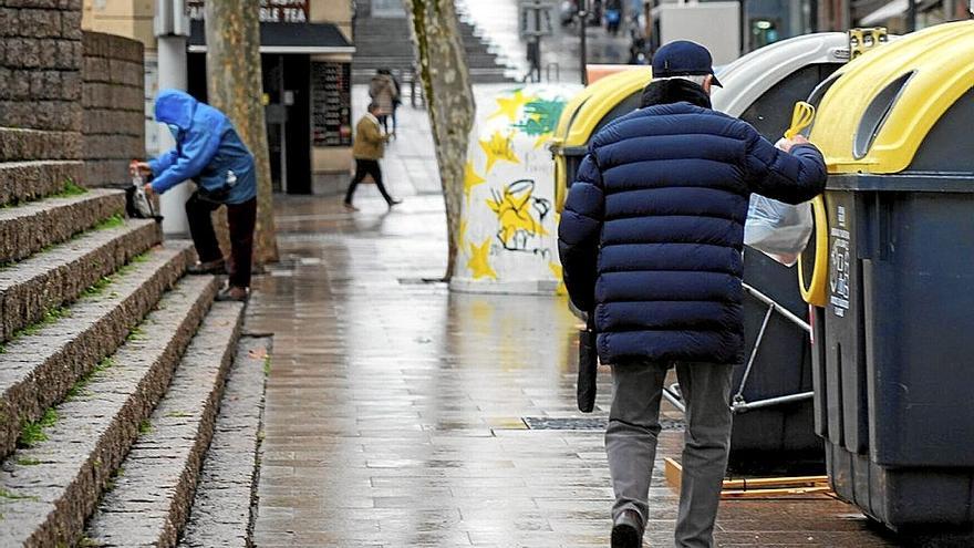 Gizon batek zaborra botatzen, Gasteizko birziklatzeko edukiontzietan.