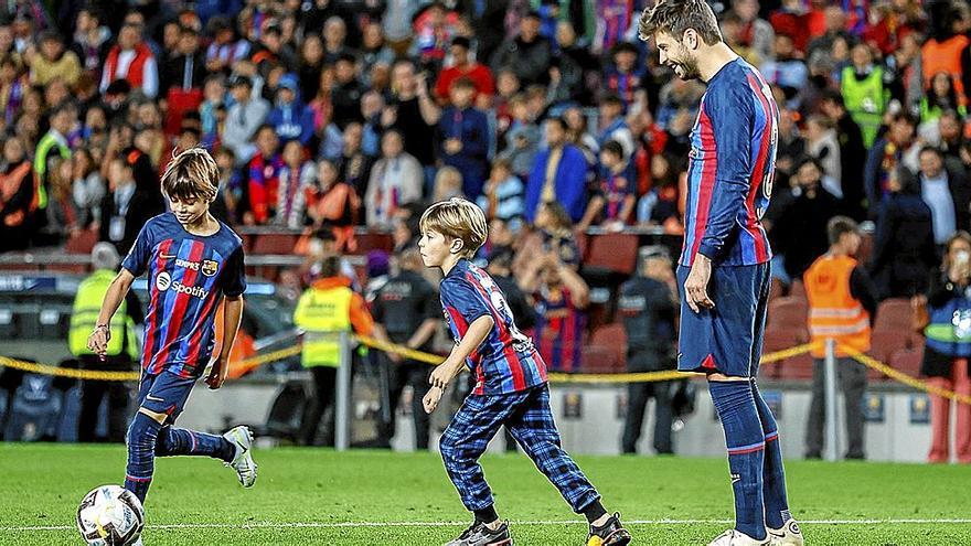 Piqué, jugando con sus dos hijos en el césped del Camp Nou tras su despedida.