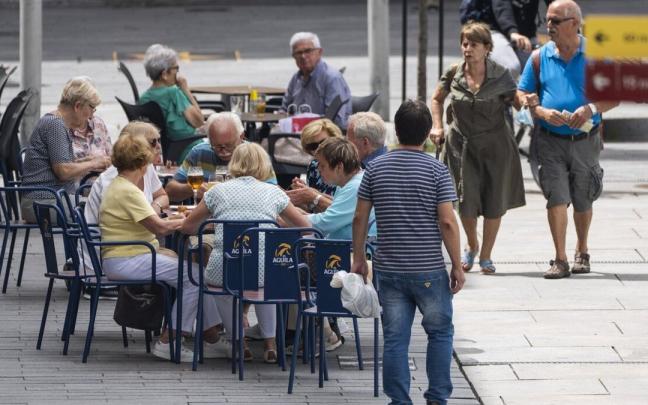 Personas sentadas en la terraza de un bar en Vitoria durante una ola de calor.
