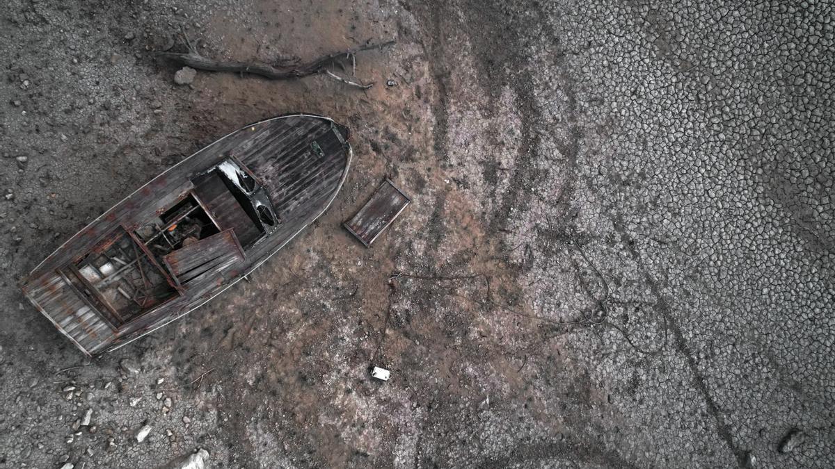 Imagen tomada el miércoles desde un dron de una barca sobre la superficie seca y cuarteada de la tierra del pantano de Yesa.