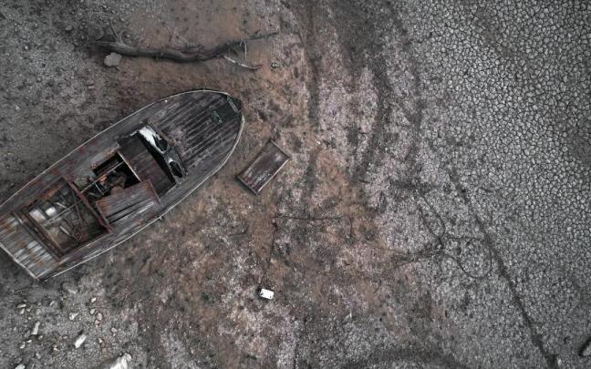 Imagen tomada el miércoles desde un dron de una barca sobre la superficie seca y cuarteada de la tierra del pantano de Yesa.