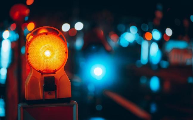 Primer plano de una lámpara de advertencia en una calle por la noche.