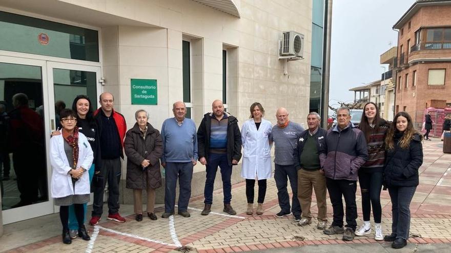 En el centro de la imagen Iván Vergara y la enfermera Arantza de Miguel; a la izquierda con bata blanca la farmacéutica de Sartaguda, Charo Echarri, junto a varios vecinos y vecinas en la puerta del consultorio de Sartaguda.