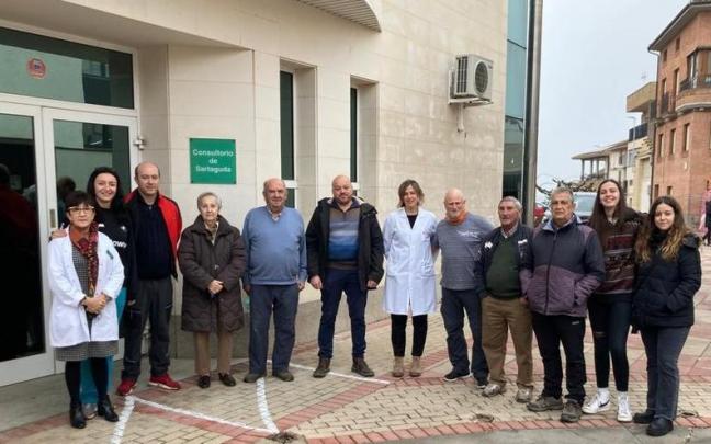 En el centro de la imagen Iván Vergara y la enfermera Arantza de Miguel; a la izquierda con bata blanca la farmacéutica de Sartaguda, Charo Echarri, junto a varios vecinos y vecinas en la puerta del consultorio de Sartaguda.