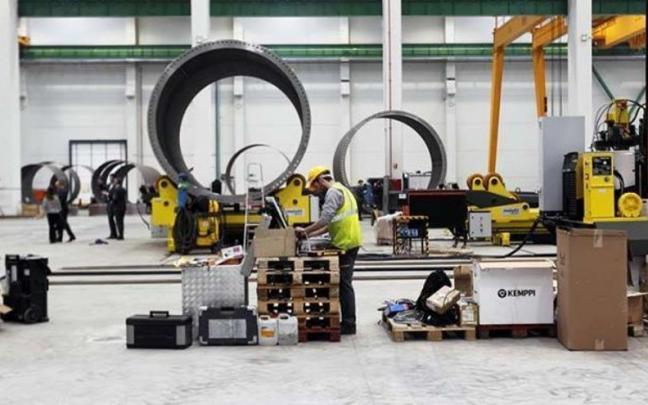 Varios operarios trabajan en una empresa dedicada al sector industrial. Varios operarios trabajan en una empresa dedicada al sector industrial.