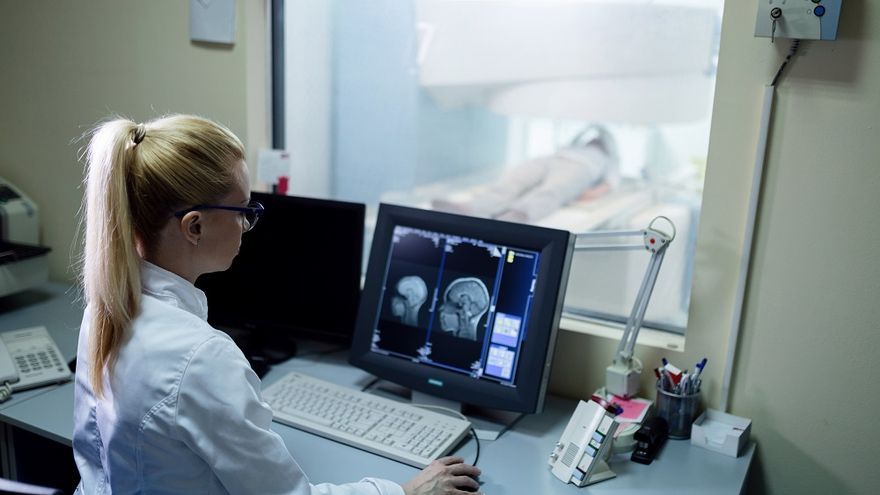 Una radióloga analiza los resultados de la resonancia magnética cerebral de un paciente.