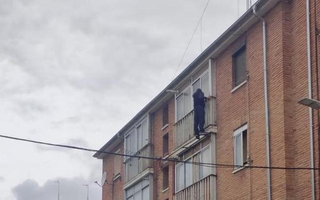 El hombre encaramado a la ventana de su casa.