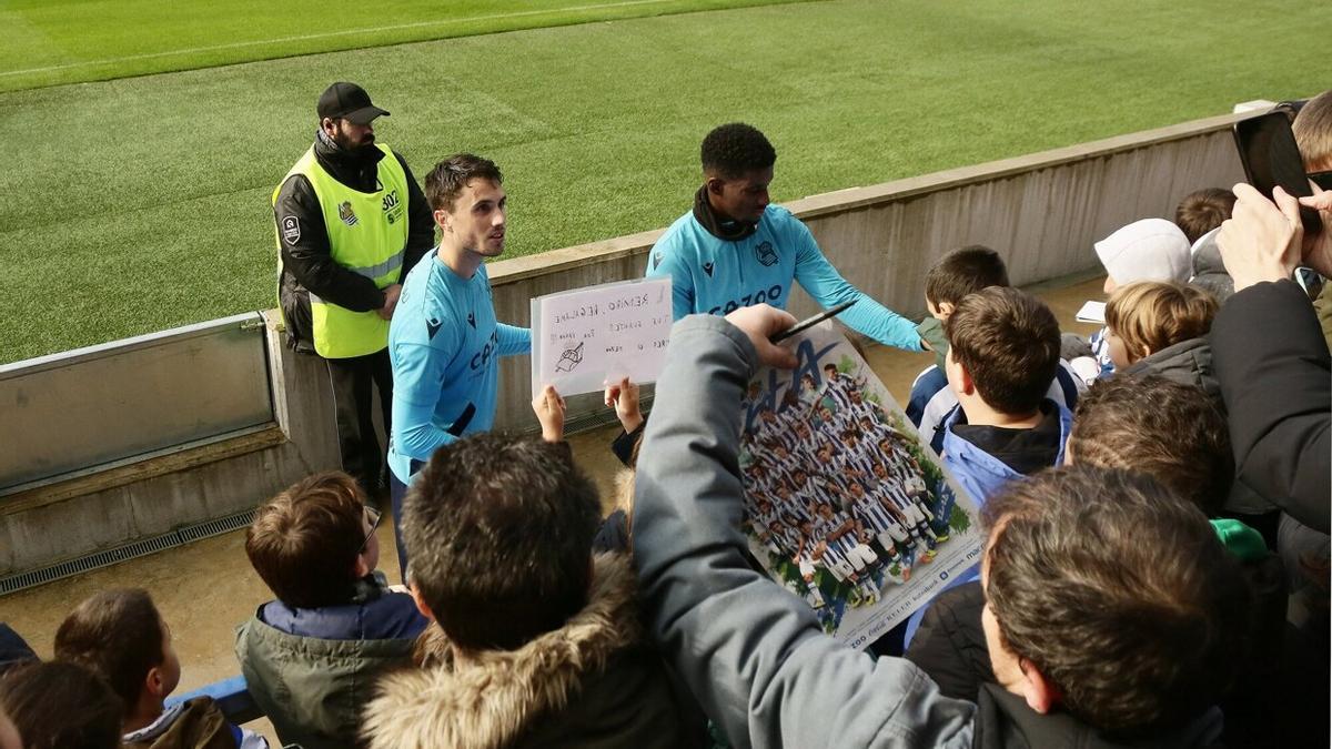 Guevara y Cho atienden las peticiones de un grupo de aficionados, tras concluir el entrenamiento.