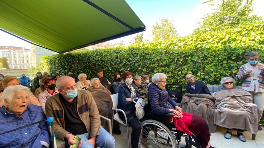 Mayores y familiares escuchan la charla de Brian y Norber en la residencia Albertia, junto a Carlos de Astrolibros