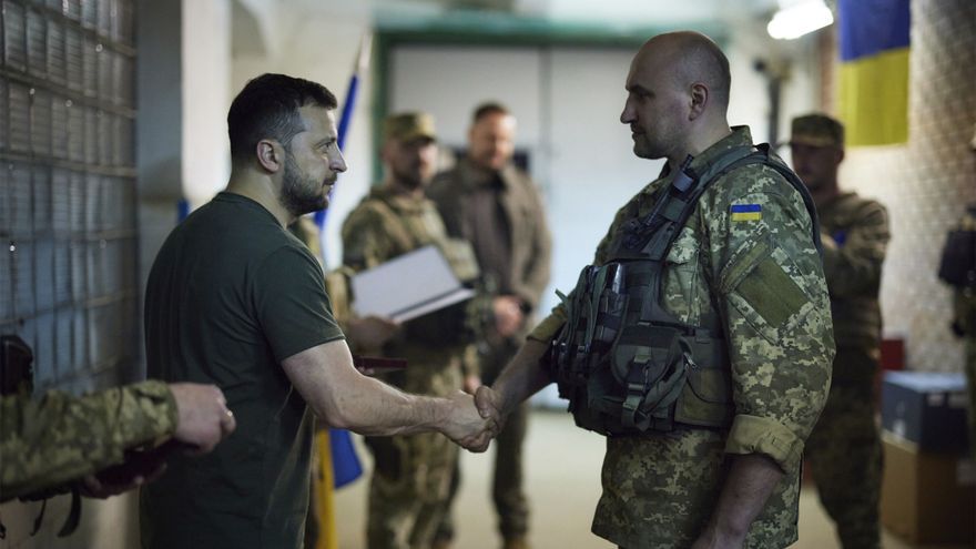 El presidente ucraniano, Volodimir Zelenski (izq.), saluda a un soldado (der.) en el frente de Donetsk.