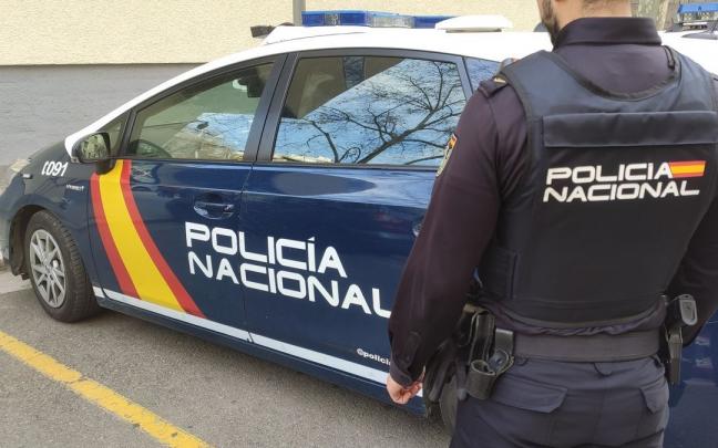 Un agente de la Policía Nacional en Palma junto al coche policial. Un agente de la Policía Nacional en Palma junto al coche policial.