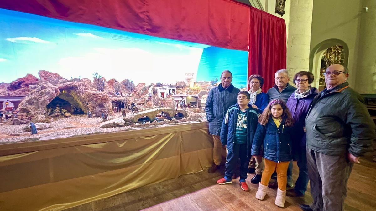 Algunos de los belenistas de Lodosa posan junto al Belén que han elaborado durante meses y que ya luce en la parroquia de la localidad.