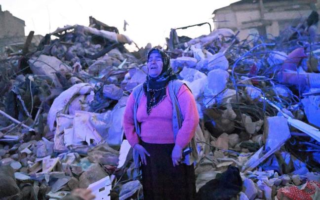 Una mujer llora entre los escombros mientras espera noticias de sus familiares en la localidad turca de Hatay.