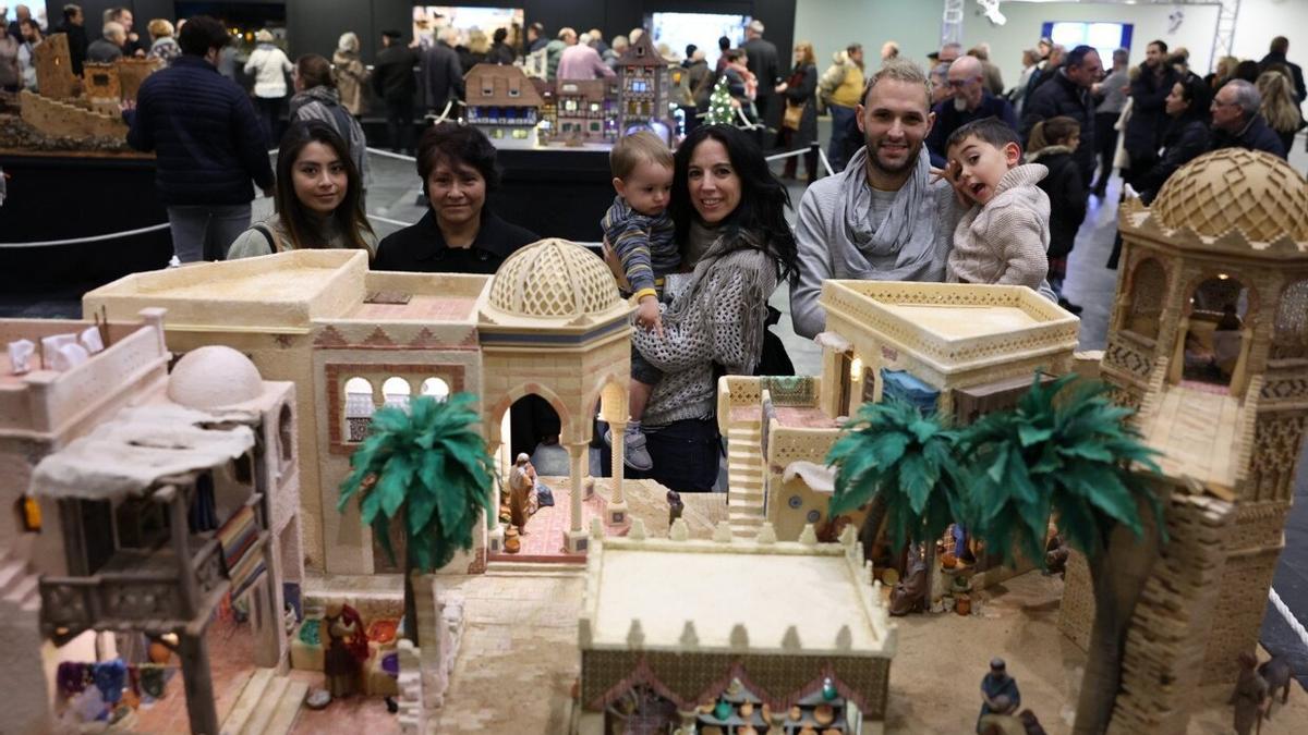 Silvia y Antonio, con sus dos hijos y dos integrantes de su grupo, frente a su belén.