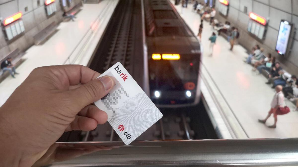 Una persona muestra su tarjeta Barik desde la plataforma de acceso a los andenes del metro.