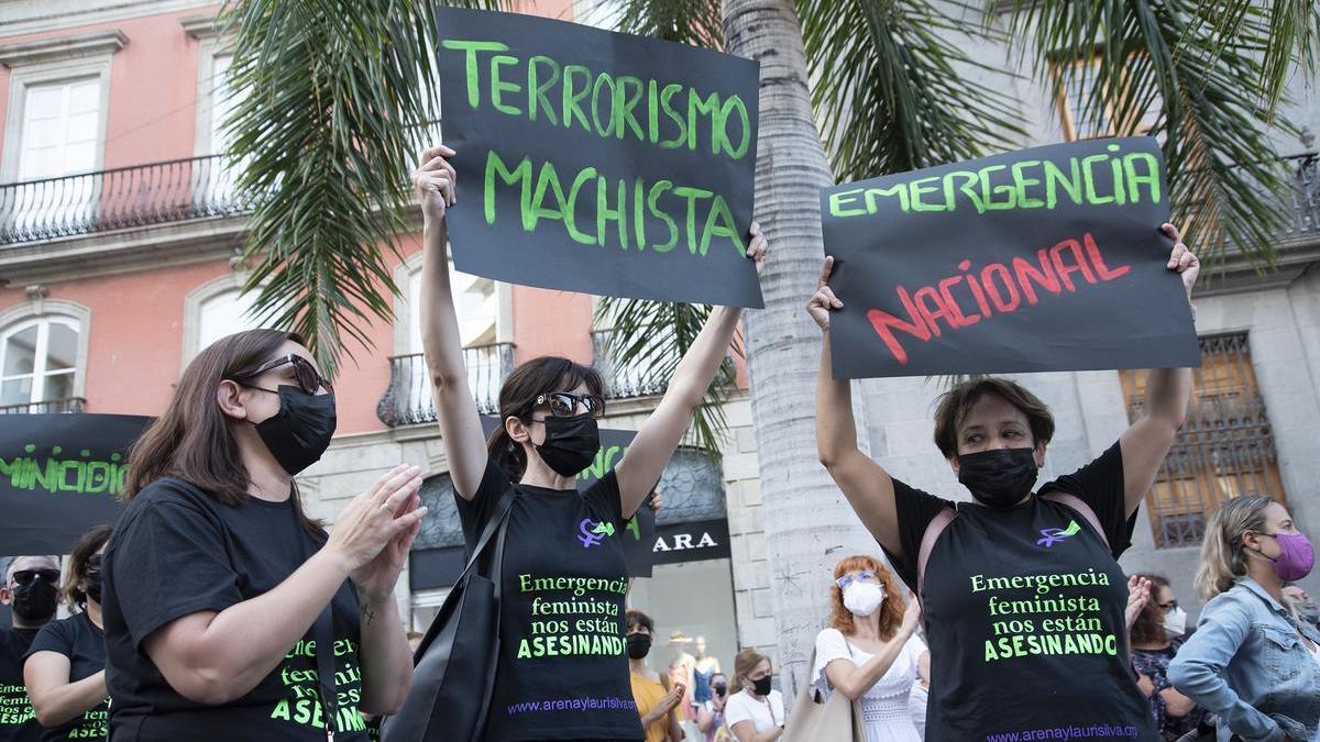 Dos mujeres con un cartel en el que se lee: `Terrorismo machista´, participan en una concentración