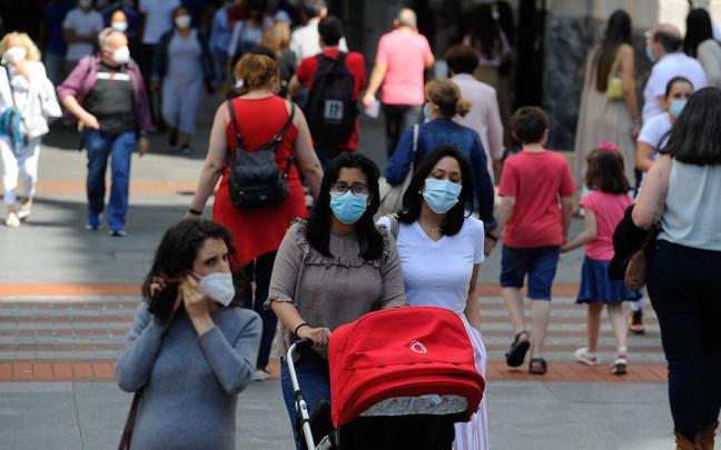 Varias personas caminan por la calle.