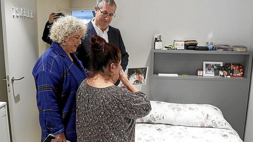 Isabel muestra a sus invitados, el diputado general, Markel Olano, y la diputada Maite Peña, una foto en su nueva habitación. | FOTO: EFE