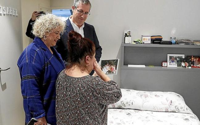 Isabel muestra a sus invitados, el diputado general, Markel Olano, y la diputada Maite Peña, una foto en su nueva habitación. | FOTO: EFE Isabel muestra a sus invitados, el diputado general, Markel Olano, y la diputada Maite Peña, una foto en su nueva habitación. | FOTO: EFE