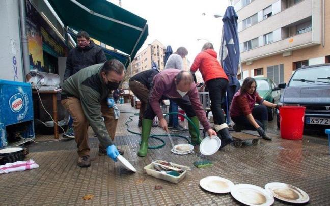 Familiares, amigos y vecinos de la Rochapea limpiando el bar Arga tras las inundaciones provocadas por el desbordamiento del r&iacute;o Arga el 10 de diciembre.