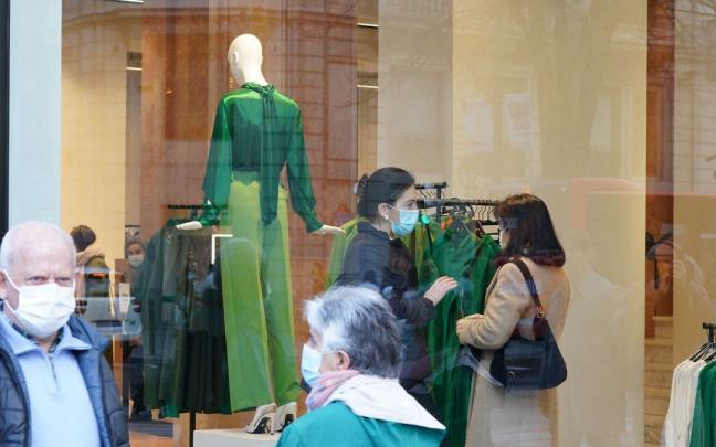 Varias personas caminan con mascarilla por la calle.