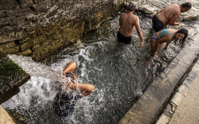 Ba&ntilde;istas refresc&aacute;ndos en el "lavadero" de Ibero, en la &uacute;ltima ola de calor.