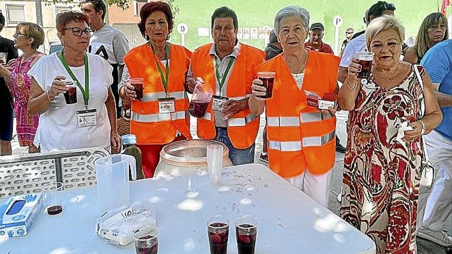 Encargadas de servir el vino con melocotón en la plaza.