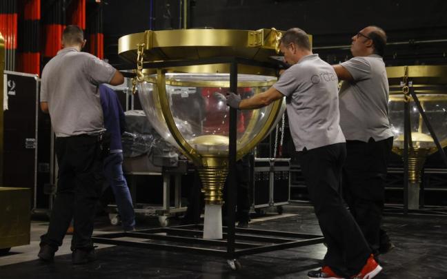 Operarios mueven los bombos de la Lotería de Navidad en el Teatro Real