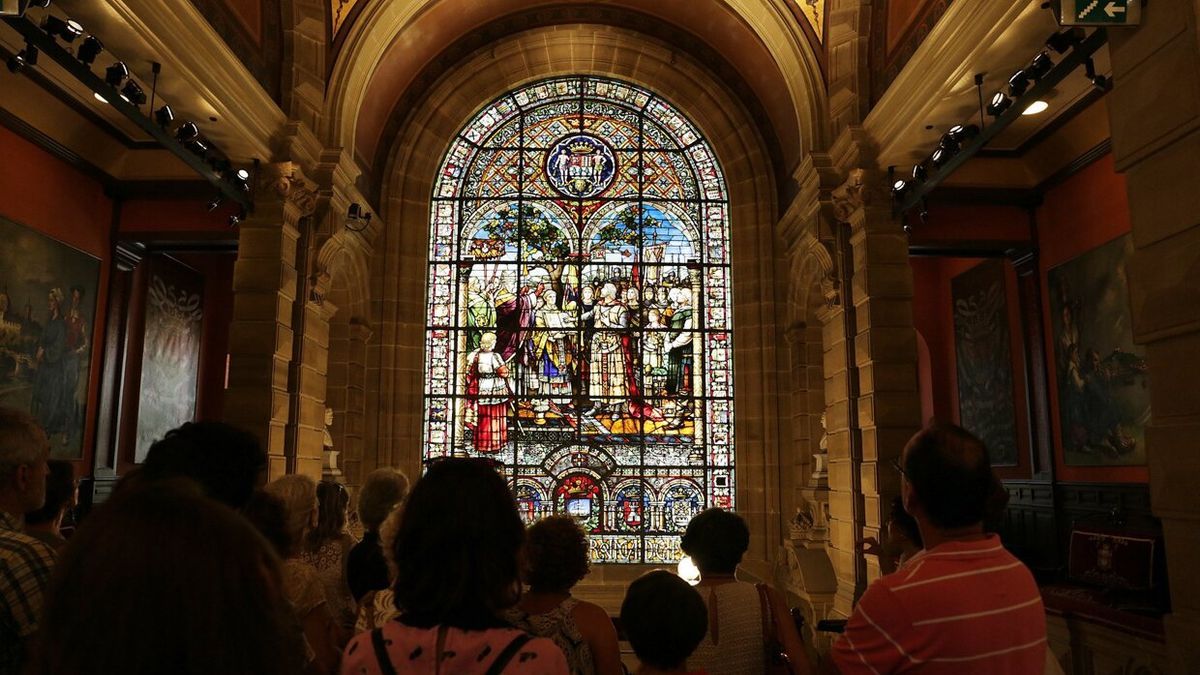 Visitantes observan una de las vidrieras del palacio foral