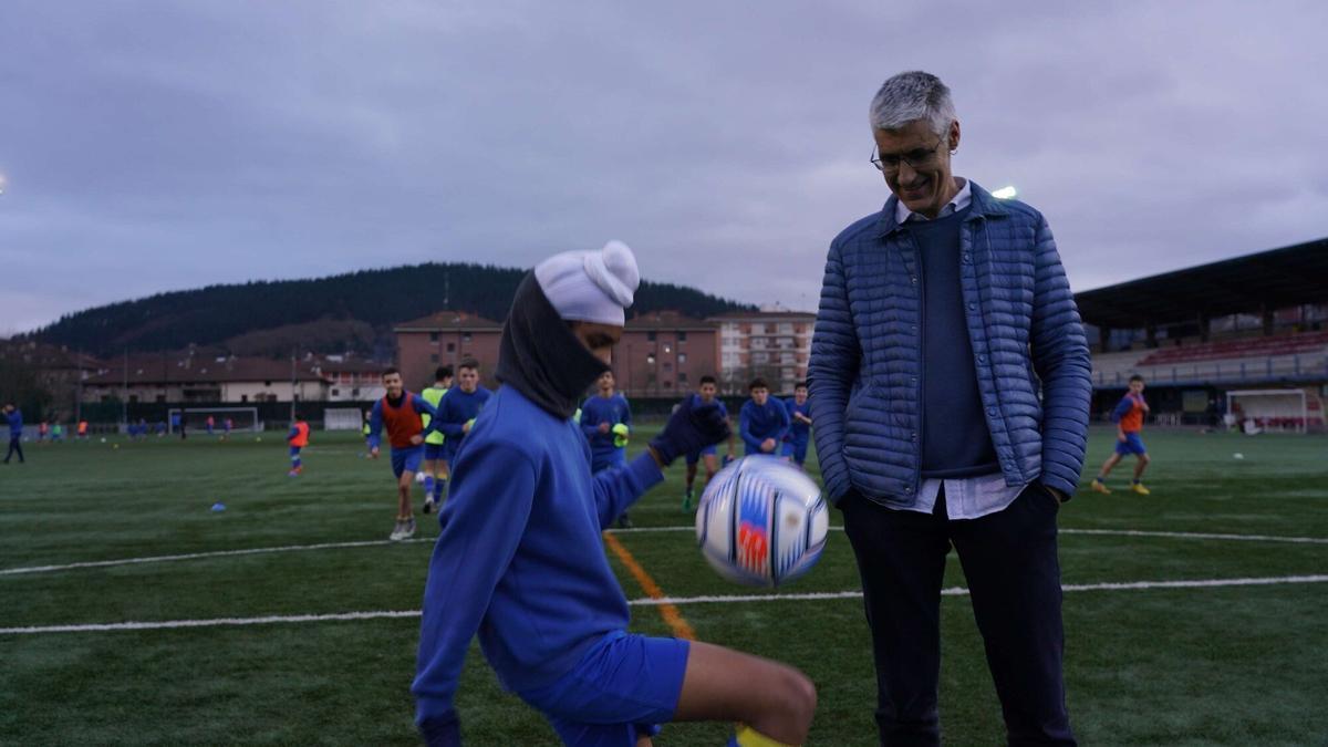 Gurpreet juega con el balón en el campo del Arratia junto al presidente, Pedro Ormazabal.