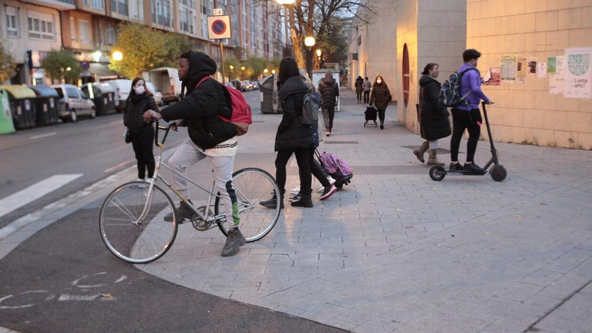 Gente paseando por Vitoria, andando, en bicicleta y en patinete.