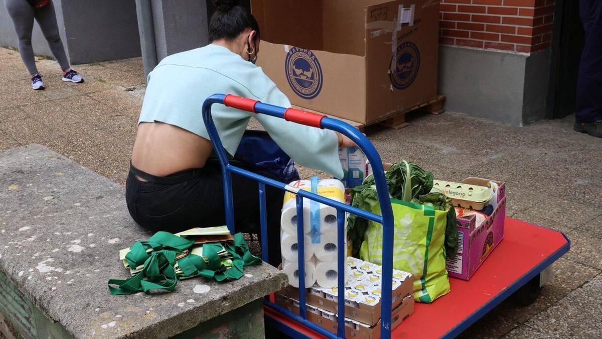 Una mujer recibe alimentos en el punto municipal de reparto de Ermitagaña.