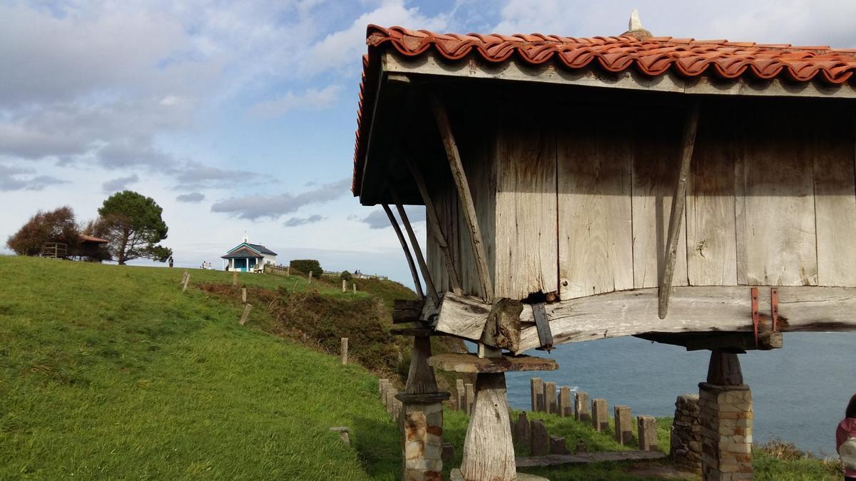 Un hórreo, con la ermita de La Regalina al fondo, símbolo de Cadavedo.