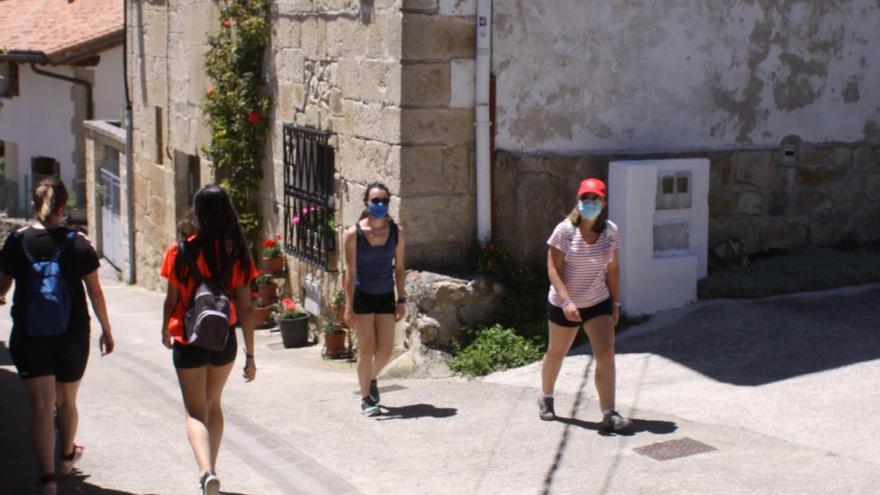 Visitantes con mascarilla paseando por Baquedano, antes de acceder al nacedero del Urederra.