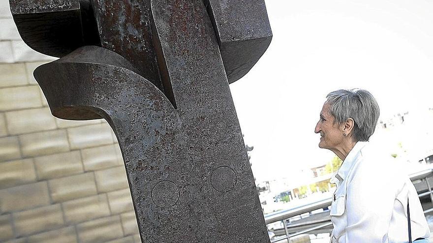 Mari Jose Aguirre contempla emocionada la obra ‘Besarkada XI’ de Chillida junto al edifico del Guggenheim. |