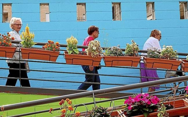 Visi, Corpus y Tere bajan las escaleras del colorido patio, reci&eacute;n pintado con motivos de Berriozar.