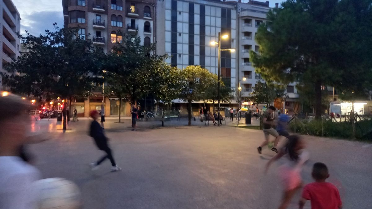Chavales corriendo a por un balón en la plaza Catalunya