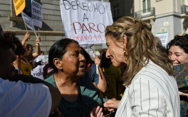 Yolanda Díaz charla con una empleada doméstica durante una protesta en Madrid.
