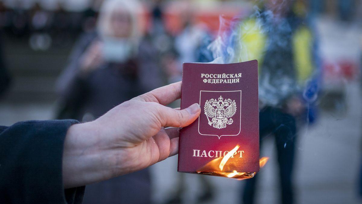 Un hombre quema un pasaporte ruso